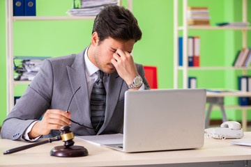 Young handsome lawyer working in the office 