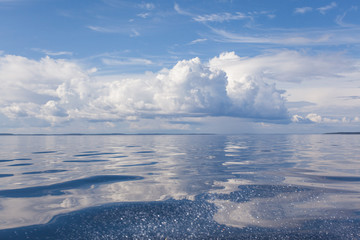 Cumulus white clouds over the water surface of Ladoga Lake. Karelia. 