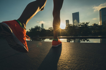 Fototapeta na wymiar Healthy lifestyle woman runner legs running on sunrise city