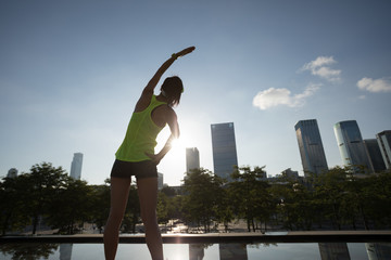 Fitness woman runner warming up before running