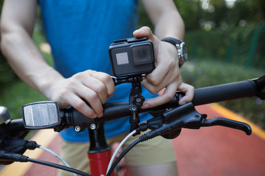Cyclist mounting the action camera on mountain bike