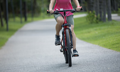 Fototapeta na wymiar Woman riding mountain bike in tropical park