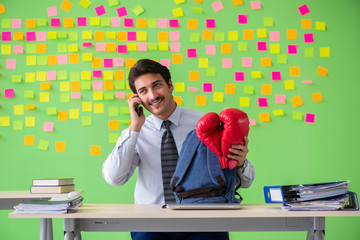 Man with boxing gloves in the office with many conflicting prior