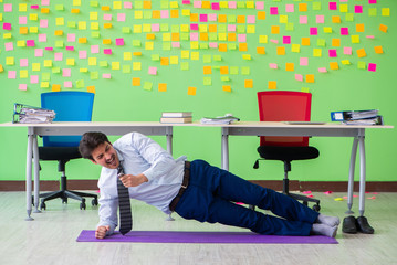 Man in the office with many conflicting priorities doing exercis