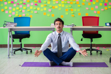 Man in the office with many conflicting priorities doing exercis