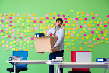 Man collecting his stuff after redundancy in the office with man