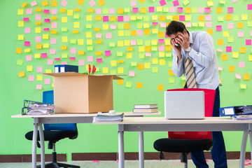 Man collecting his stuff after redundancy in the office with man