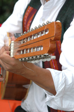 Male guitarist performing in concert outdoors.