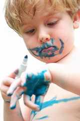 Young boy drawing on himself with a marker