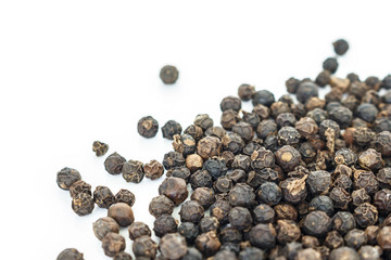 black peppercorns heap on white background.