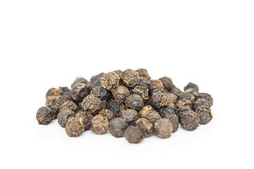 black peppercorns heap on white background.
