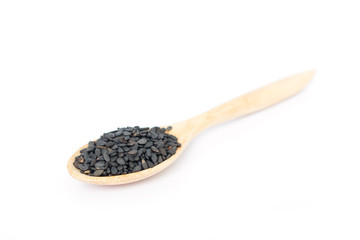 Heap of black sesame on wooden spoon on white background.