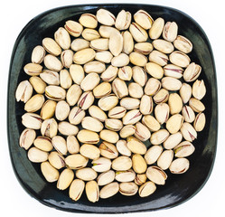 pistachio in plate on white background.