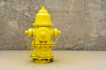 Urban landscape of bright yellow fire hydrant in concrete alcove