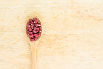 red bean seed spoon top view on wooden background