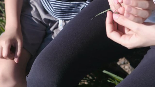 Mom puts on her son's hand weaved braid from leaves.