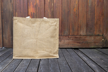 Jute bag on wooden floor with space on wood background, eco friendly bag, grocery shopping bag