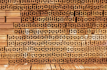 Stack of red brick wall texture background, natural red soil color brick, construction site