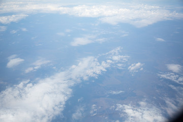 Fototapeta premium Clouds and sky as seen through window of an aircraft