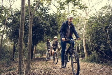Naklejka premium Group of friends ride mountain bike in the forest together