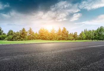 Foto op Canvas Asphalt road and green forest landscape at sunset © ABCDstock