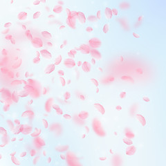 Fototapeta na wymiar Sakura petals falling down. Romantic pink flowers gradient. Flying petals on blue sky square backgro