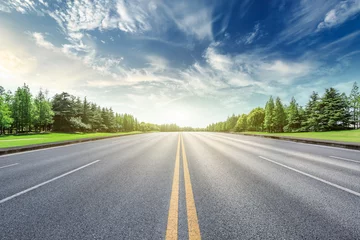 Foto op Canvas Asphalt road and green forest landscape under the blue sky © ABCDstock