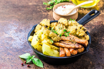 Roasted vegetables with olive oil and herbs in cast iron skillet. Selective focus, space for text.