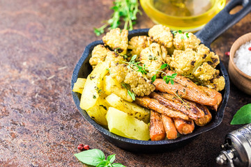 Roasted vegetables with olive oil and herbs in cast iron skillet. Selective focus, space for text.