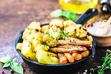 Roasted vegetables with olive oil and herbs in cast iron skillet. Selective focus, space for text.