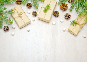 Christmas background tree branches cones and gifts on wooden white background 