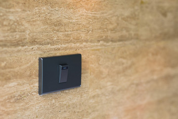 Close up gray light switch with stone wall background