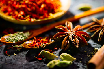 Specerijen. Diverse Indiase kruiden op zwarte stenen tafel. Spice en kruiden op leisteen achtergrond. Ingrediënten koken