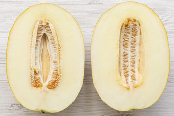 Two halves of melon on white wooden background, top view. Flat lay, overhead, from above.