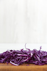 Chopped red cabbage on cutting board, closeup. Side view.