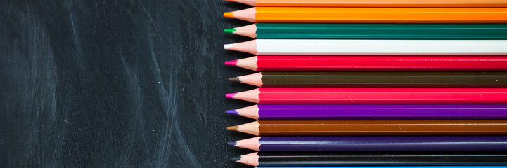 Back to School concept. Color pencils on blackboard background. Close up, flat lay, copy space, top view