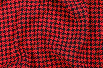 Knitted textile pattern in red and black colors as background