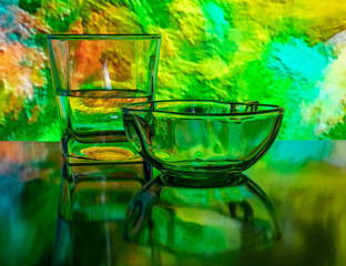 Glass of water with drop and colored background