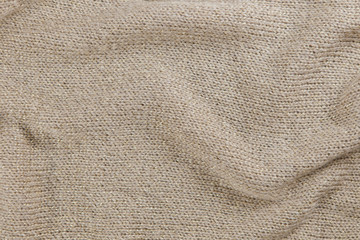 Industrial knitted textile in beige and gold colors as background