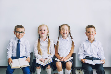 Beautiful children with books studied together in the classroom at school in uniform get educated...