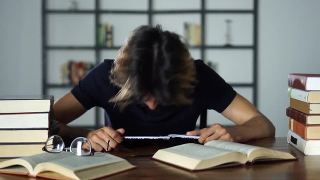 Stressed Student Tired of Studies, Banging Head on Desk Upset, Unhappy Young Man Frustrated