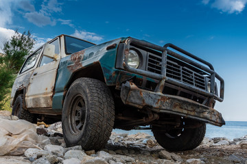 Fototapeta premium Stary, wytrzymały pojazd terenowy utknął w skalistym terenie