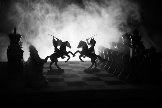 Medieval battle scene with cavalry and infantry on chessboard. Chess board game concept of business ideas and competition and strategy ideas Chess figures on a dark background