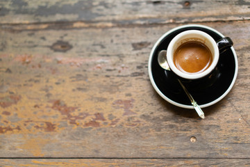 espresso coffee with brown creama in the cup on wooden table