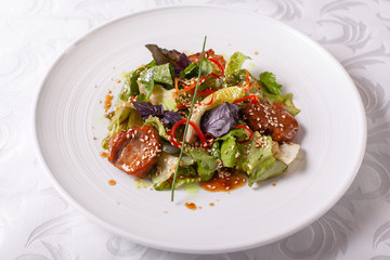 Bowl of salad with beef teriyaki and vegetables. Asian food. Salad on a white dish on table. restaurant menu