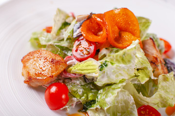 Bowl of salad with duck, orange and vegetables. Asian food. Salad on a white dish on table. restaurant menu