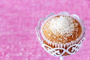Homemade vanilla muffins with coconut powder. Pink background. Copy space. Selective focus. Blur motion.