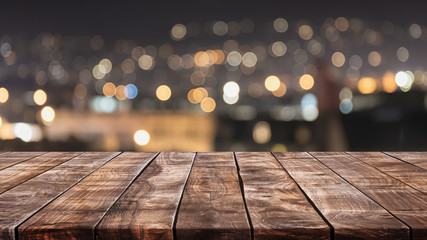 Empty wood table top and blurred bokeh light of city background with vintage filter - can used for...