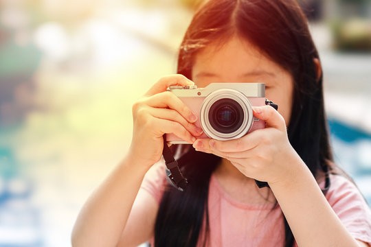 Asian Child Holding Camera Taking Photo Illustrating Travelling Concept