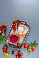 Food Vegetables. A composition of fresh tomato and sauce and a sauce in a glass jar on a light blue background with copy space, a patterned frame a flat  lay,top view